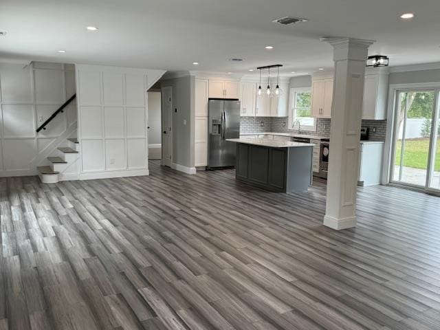 kitchen with open floor plan, tasteful backsplash, plenty of natural light, and stainless steel fridge