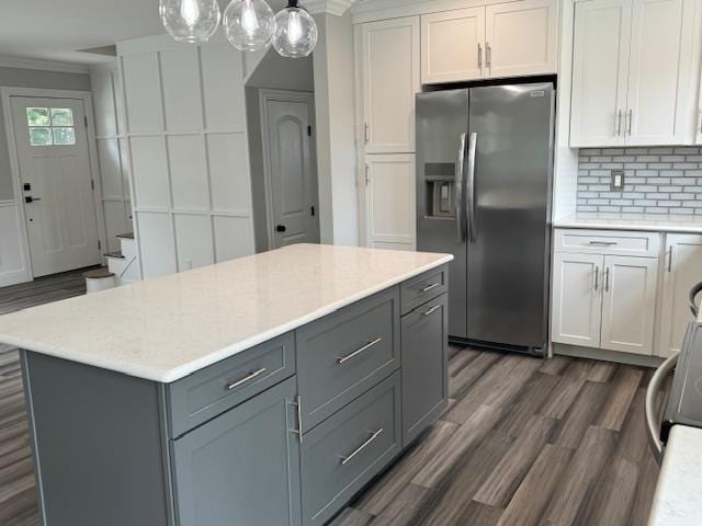 kitchen with stainless steel fridge, decorative backsplash, gray cabinets, and crown molding