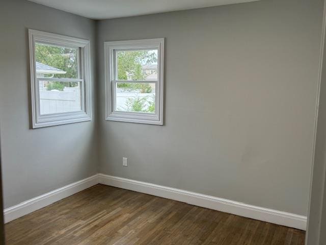 unfurnished room featuring dark wood finished floors and baseboards