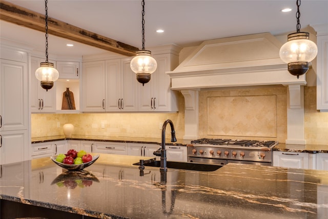 kitchen featuring custom range hood, white cabinets, a sink, recessed lighting, and tasteful backsplash