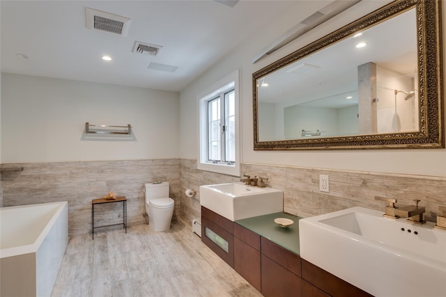 full bathroom featuring tile walls, toilet, a wainscoted wall, a shower, and a baseboard heating unit
