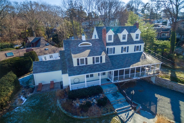 view of front of home featuring a chimney and a sunroom