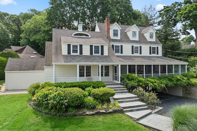 2 Valley Dr, Huntington Bay, NY 11743 - view of front of house featuring a sunroom, a chimney, a porch, a front yard, and a shingled roof