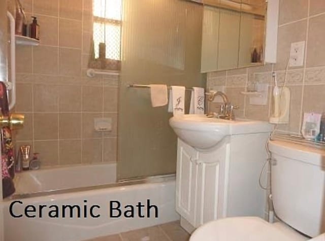 bathroom featuring tasteful backsplash, vanity, toilet, and shower / bathtub combination