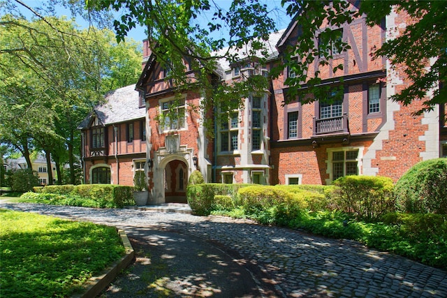 view of front of home featuring a chimney and brick siding