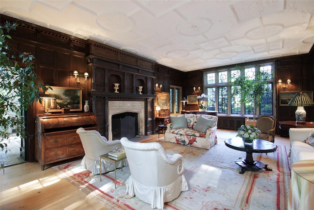 living area featuring a fireplace, wooden walls, and light wood finished floors