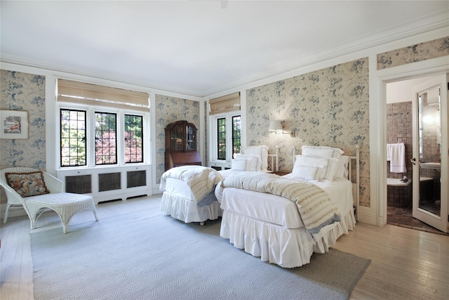 bedroom featuring wallpapered walls, crown molding, and wood finished floors