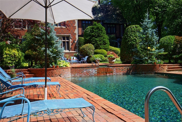 pool with a patio and an outdoor fire pit