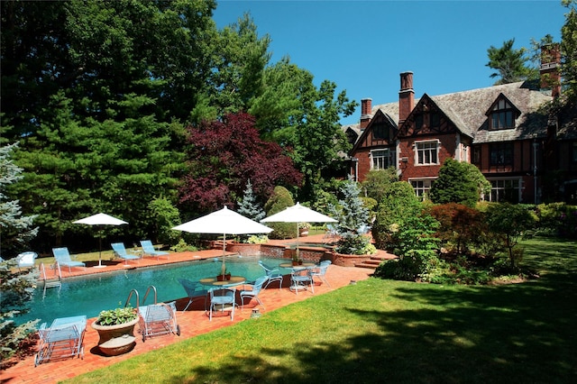 outdoor pool with a patio and a yard