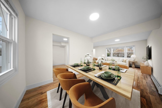 dining room with recessed lighting, wood finished floors, a baseboard radiator, and baseboards