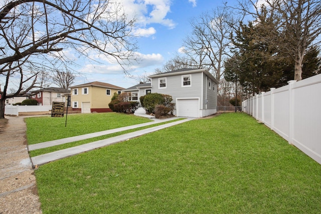 view of yard featuring fence, driveway, and an attached garage