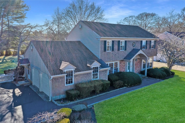 view of front facade featuring fence, driveway, an attached garage, a shingled roof, and a front lawn