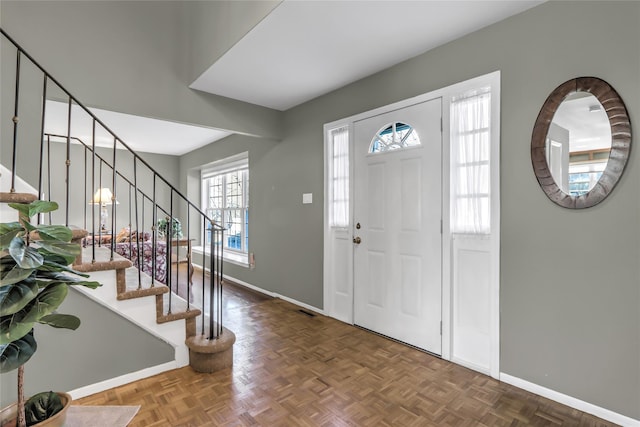 foyer entrance featuring visible vents, baseboards, and stairs