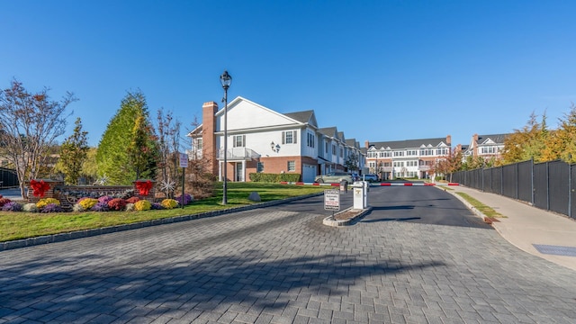 view of street with street lights, curbs, sidewalks, and a residential view