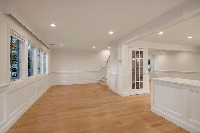 empty room featuring recessed lighting, visible vents, a decorative wall, stairway, and light wood-type flooring