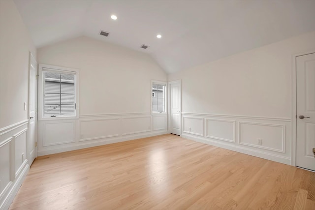 unfurnished room with light wood-type flooring, recessed lighting, visible vents, and lofted ceiling