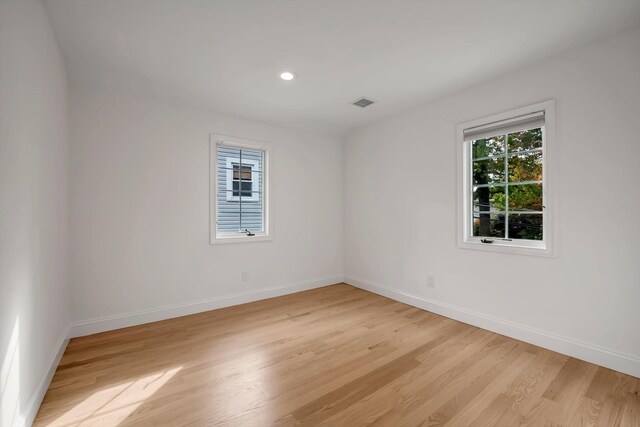 unfurnished room with recessed lighting, light wood-type flooring, visible vents, and baseboards