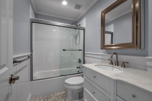 full bathroom with enclosed tub / shower combo, toilet, a wainscoted wall, vanity, and visible vents