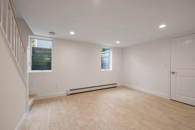 empty room with a baseboard heating unit, recessed lighting, stairs, and light wood-style floors