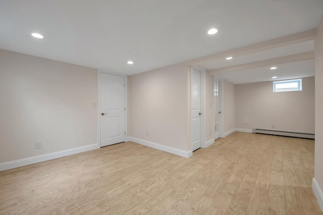 basement with recessed lighting, baseboards, light wood finished floors, and baseboard heating