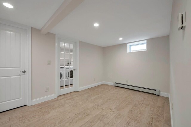 below grade area with baseboards, light wood-style flooring, baseboard heating, washer and dryer, and recessed lighting