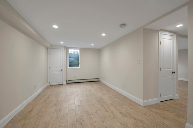 interior space with a baseboard heating unit, recessed lighting, light wood-style flooring, and baseboards