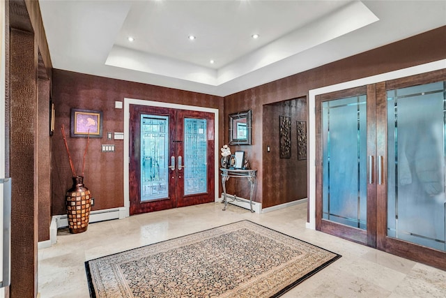 foyer featuring baseboards, a baseboard heating unit, a raised ceiling, and french doors