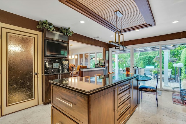 kitchen featuring visible vents, dark countertops, a center island with sink, and recessed lighting