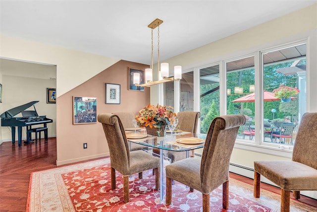 dining space with an inviting chandelier, baseboards, and wood finished floors