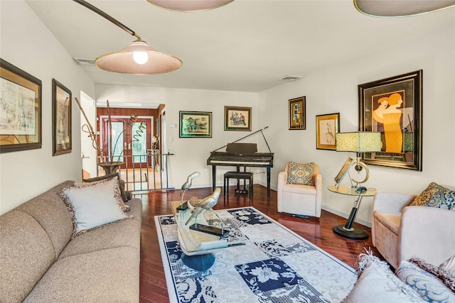 living room featuring baseboards, visible vents, and wood finished floors