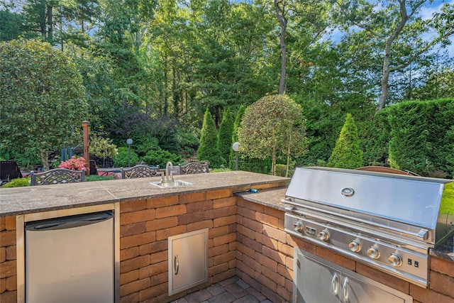 view of patio featuring outdoor dry bar, a sink, an outdoor kitchen, and area for grilling