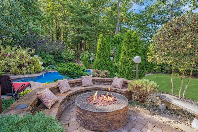 view of patio / terrace with a fire pit and an outdoor pool