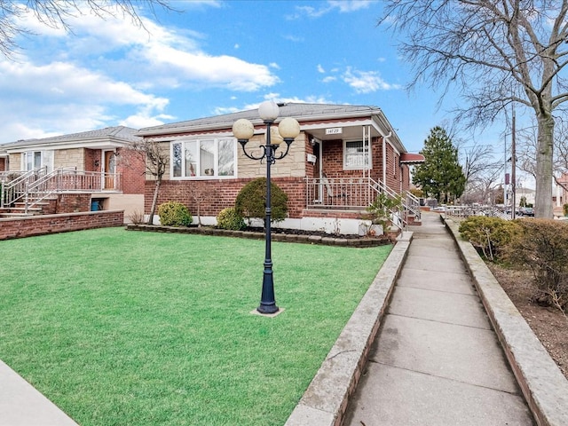 view of front of property featuring a front lawn and brick siding