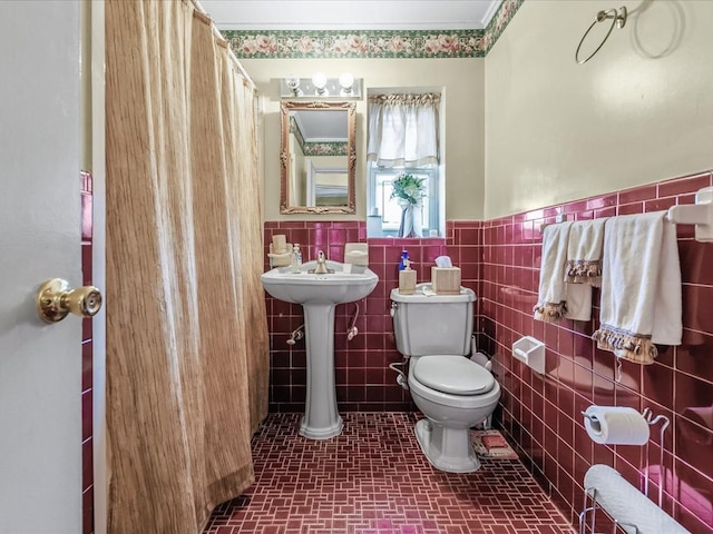 full bath featuring toilet, tile walls, and wainscoting