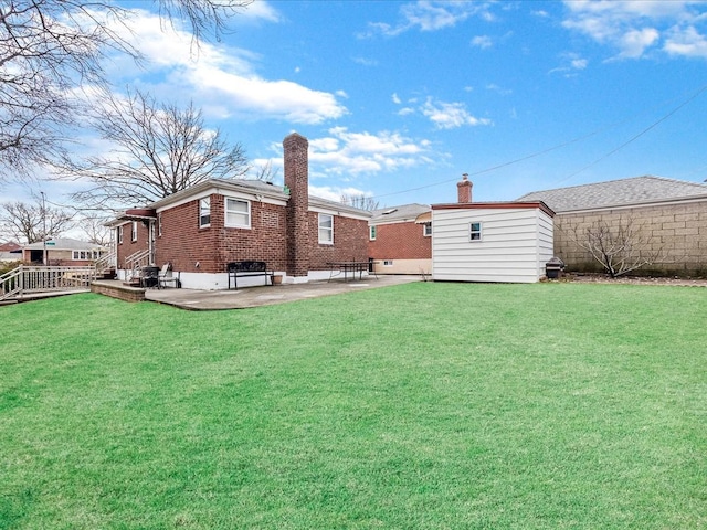 view of yard featuring a storage unit, an outbuilding, and a patio area