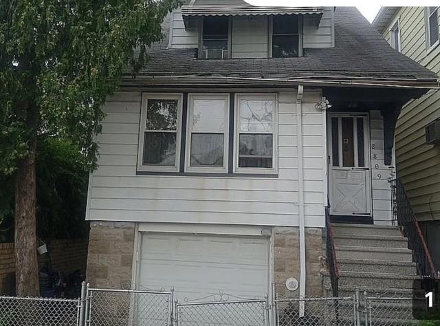 view of front of house with a gate, a garage, and a fenced front yard