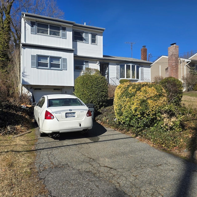 view of front facade with aphalt driveway and an attached garage