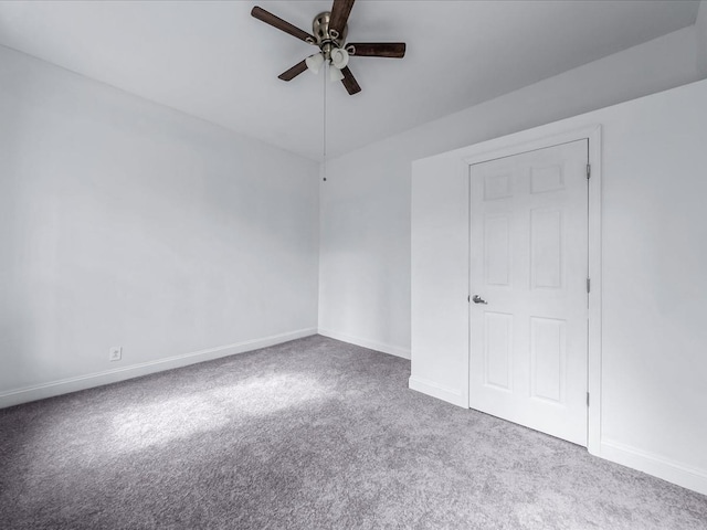 unfurnished bedroom with carpet, a ceiling fan, and baseboards