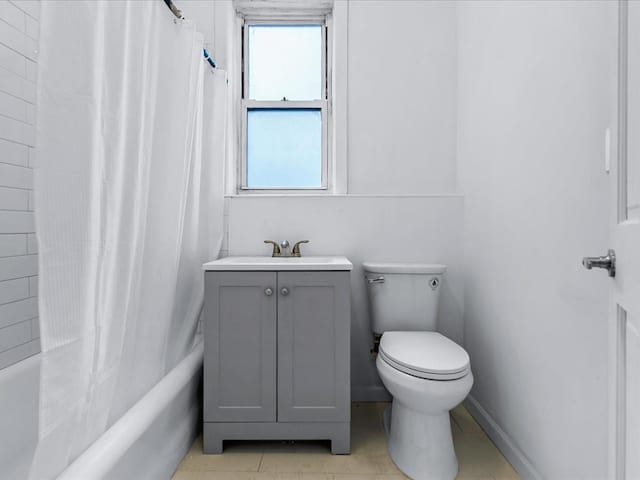 bathroom featuring toilet, shower / bath combo with shower curtain, and a sink