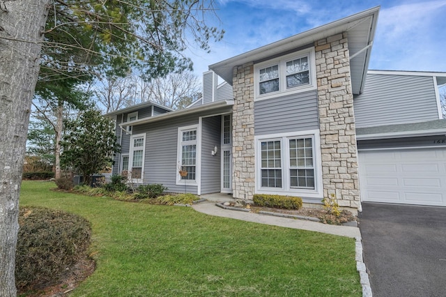 view of front of home featuring a garage, driveway, and a front yard