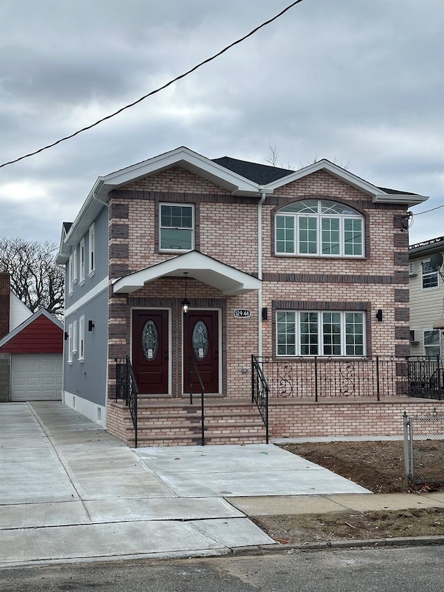 traditional-style home featuring brick siding, an outdoor structure, and a detached garage