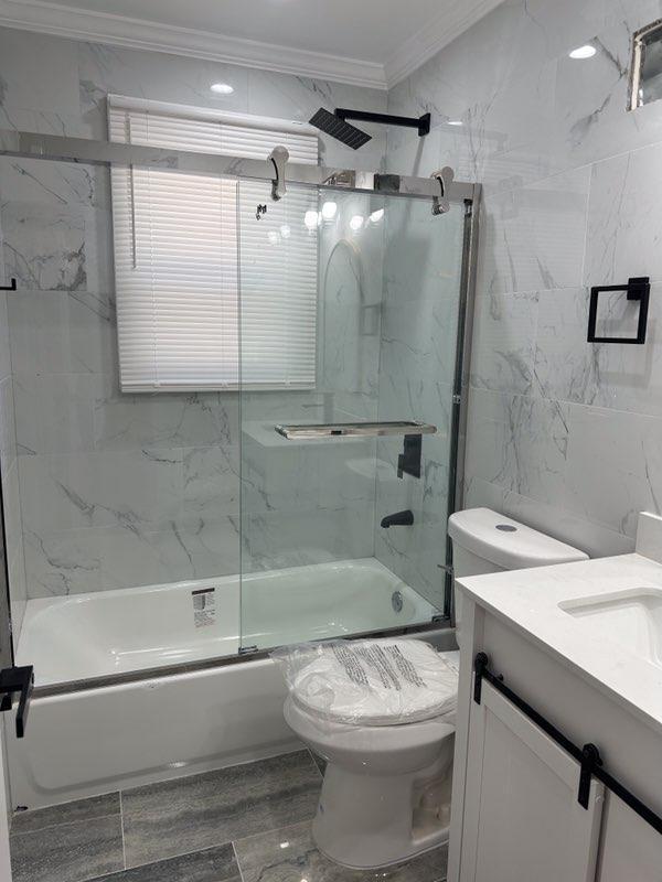 full bathroom with crown molding, tile walls, toilet, combined bath / shower with glass door, and vanity