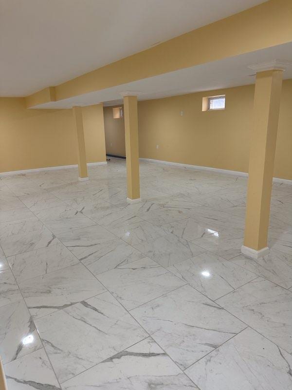 basement with marble finish floor and baseboards