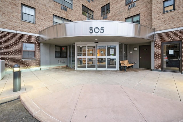 view of exterior entry featuring brick siding