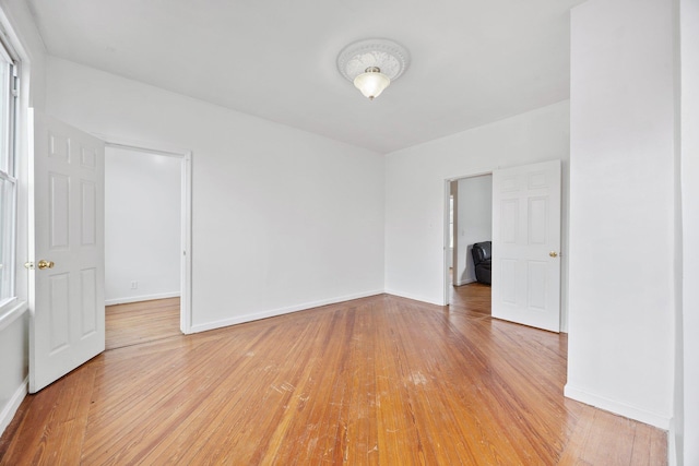 spare room with light wood-style floors and baseboards