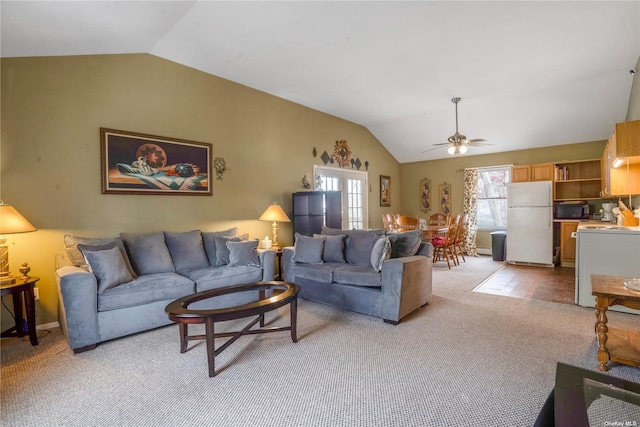 living area with lofted ceiling, a ceiling fan, and light colored carpet