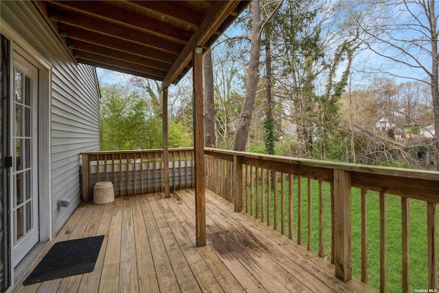 wooden deck featuring a lawn