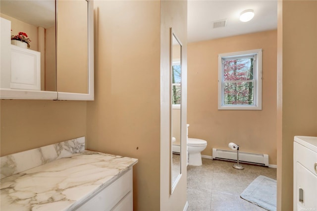 bathroom with a baseboard radiator, visible vents, toilet, washer / dryer, and tile patterned flooring