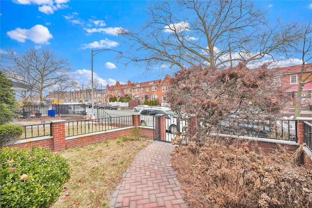 view of yard with a fenced front yard, a residential view, and a gate