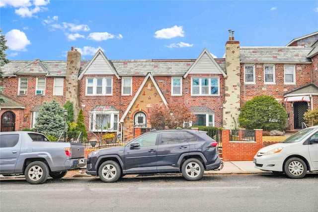 multi unit property featuring brick siding and a high end roof